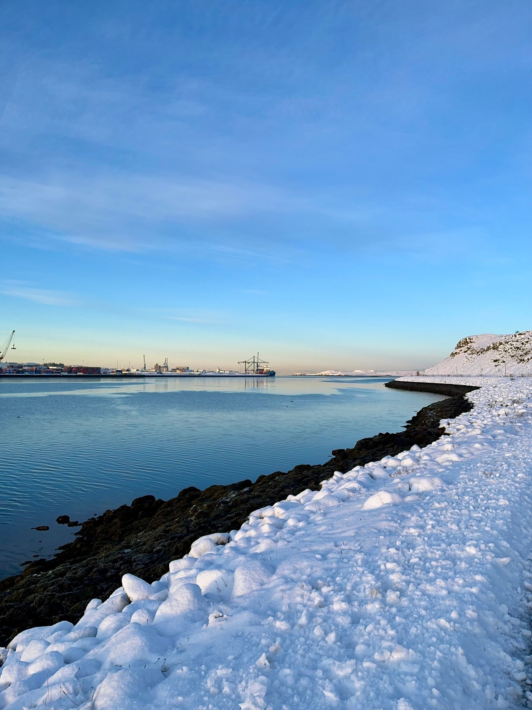 A view across the bay. You can see the rocky beach on this side and the harbour on the other.