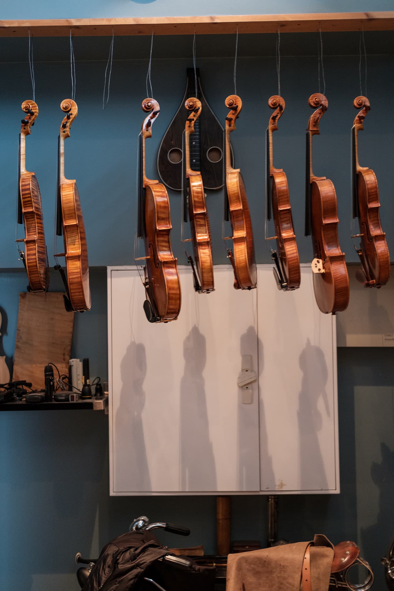 Several almost ready violins hanging in a row