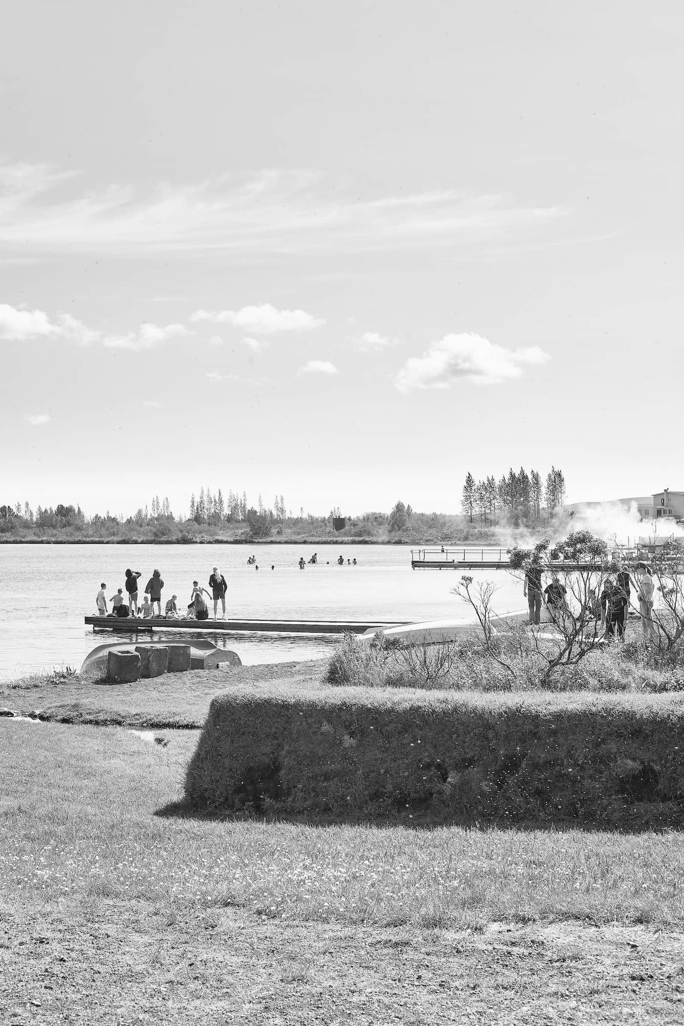 People relax at the pier in the lake