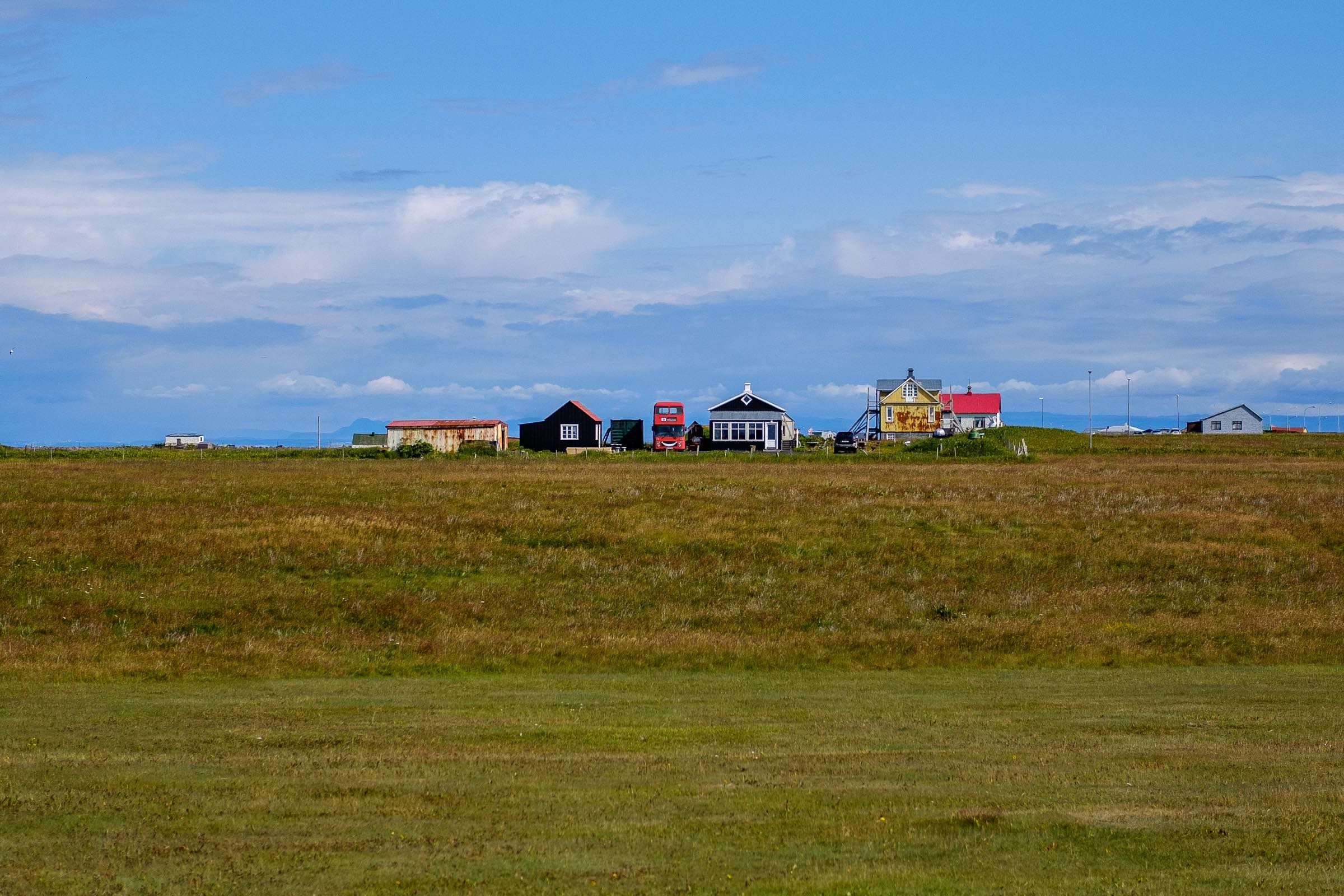 A tour bus parked next to an Icelandic farm