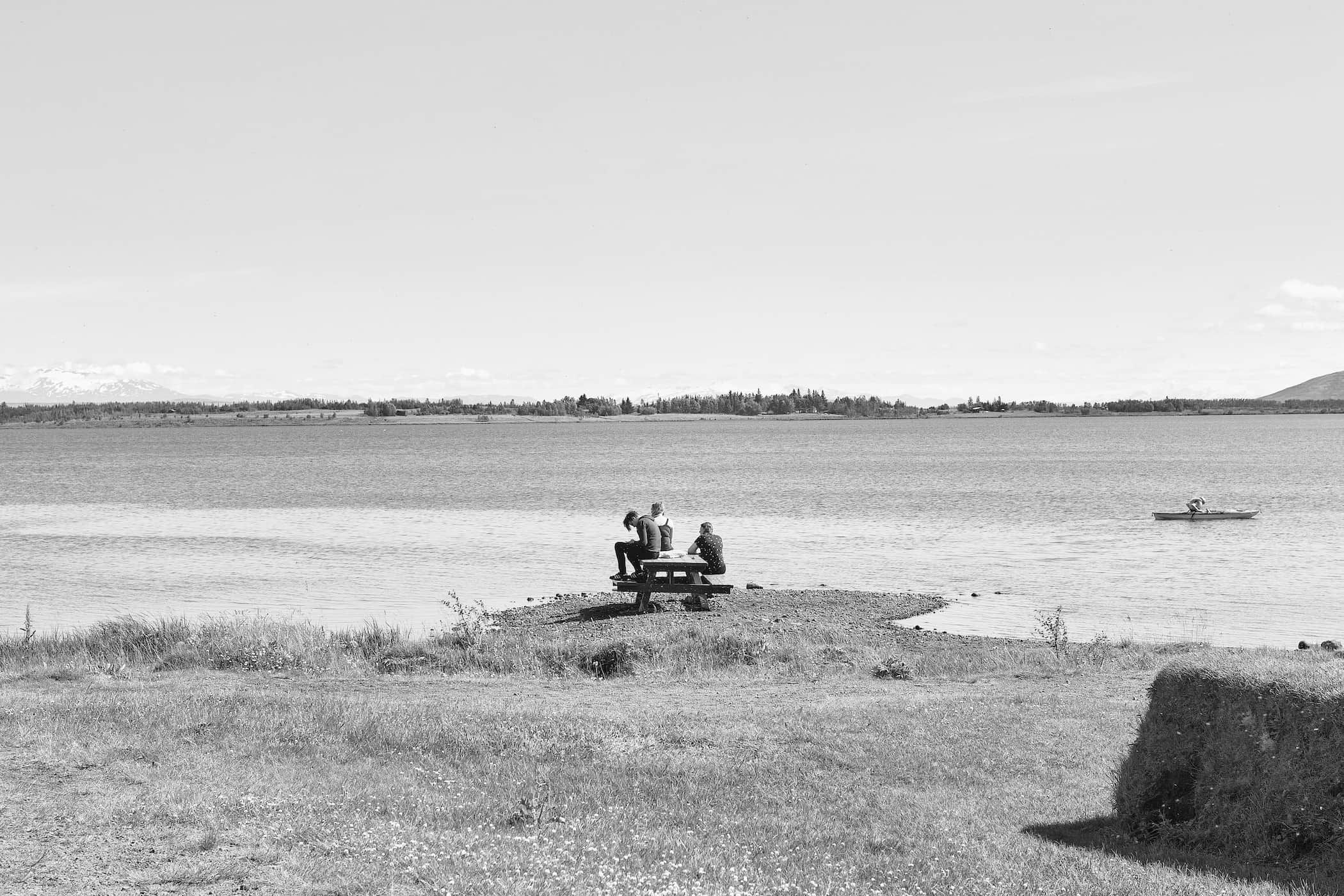 A quiet day on the shore of Laugarvatn lake as people relax on a bench